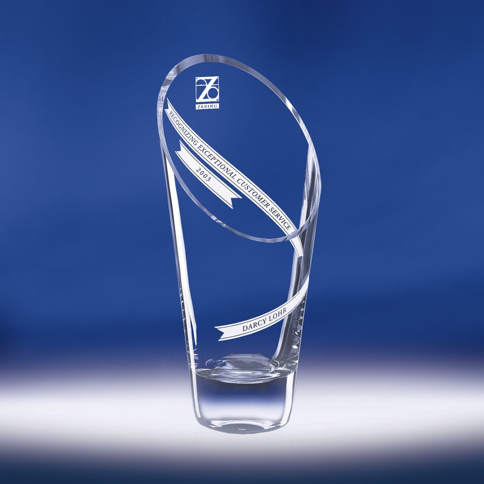 Clear glass award with engraved text on a blue background